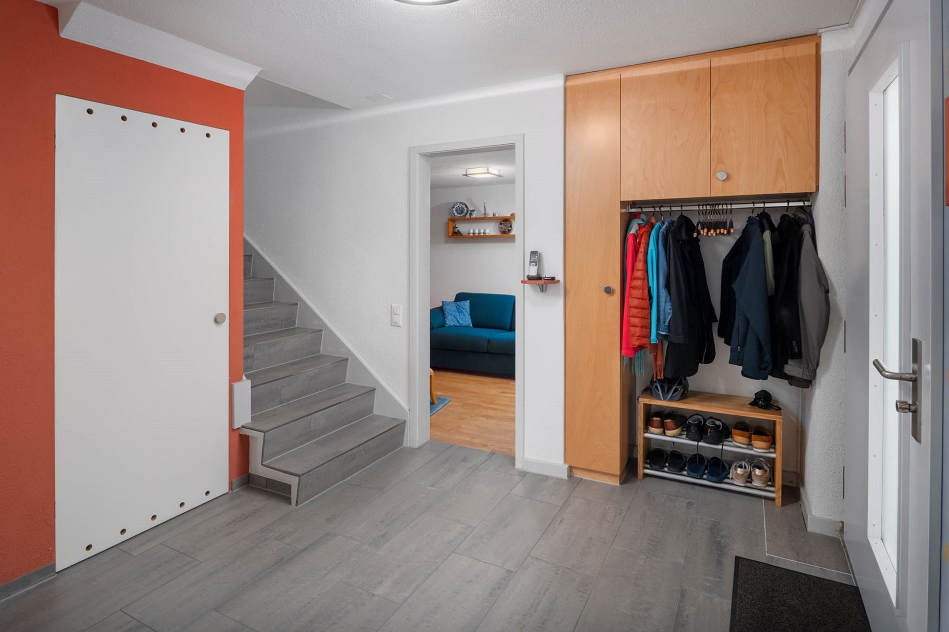 Heller Eingangsbereich mit Treppe und Garderobe