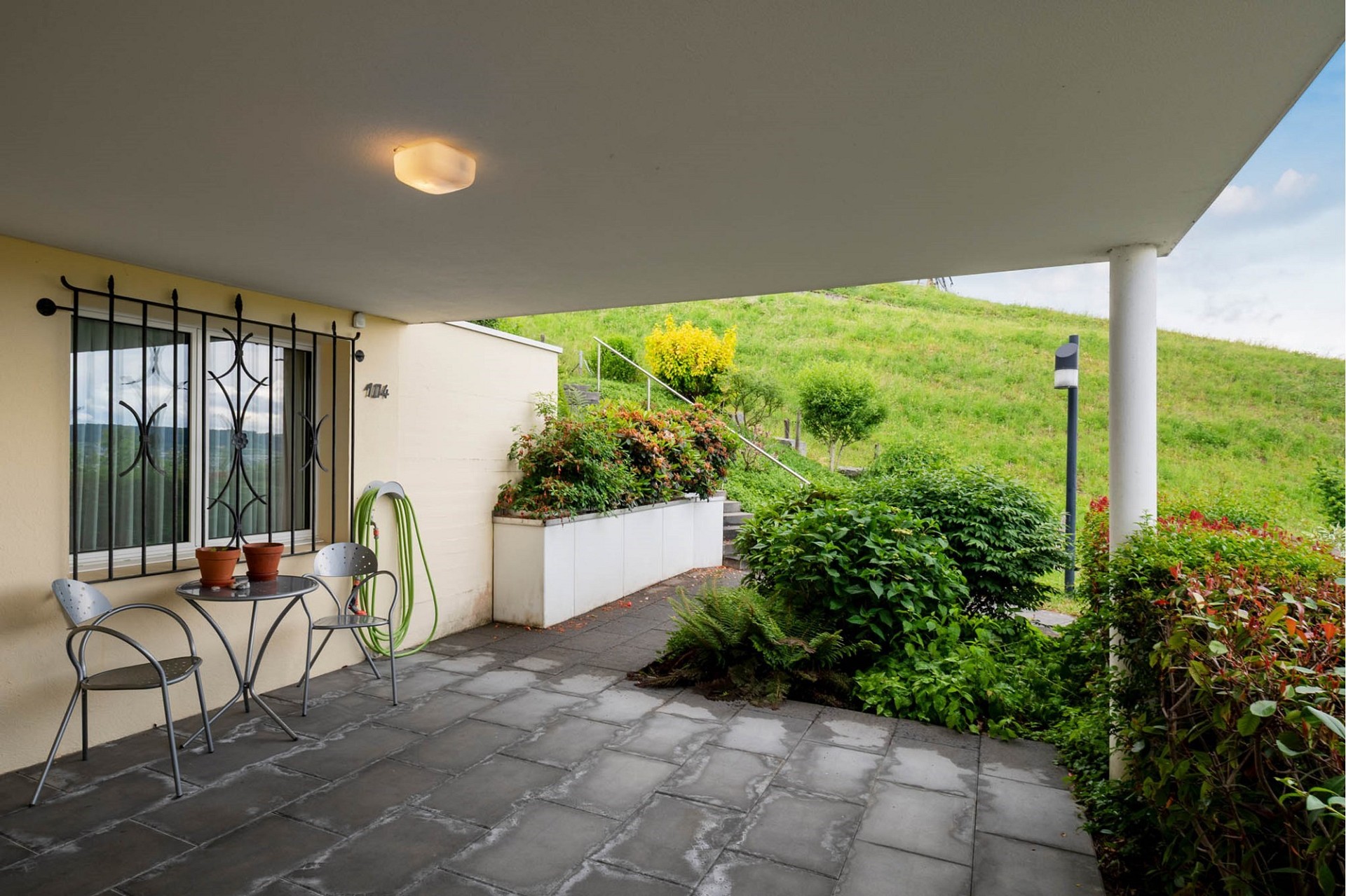 Überdachte Terrasse mit Gartenblick