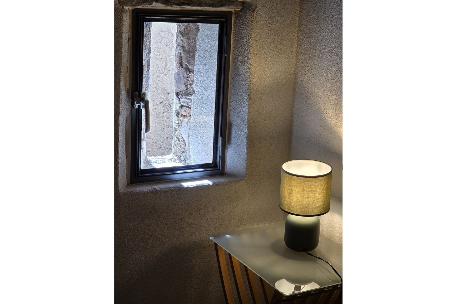 Kleiner Innenraum mit Fenster und Tischlampe