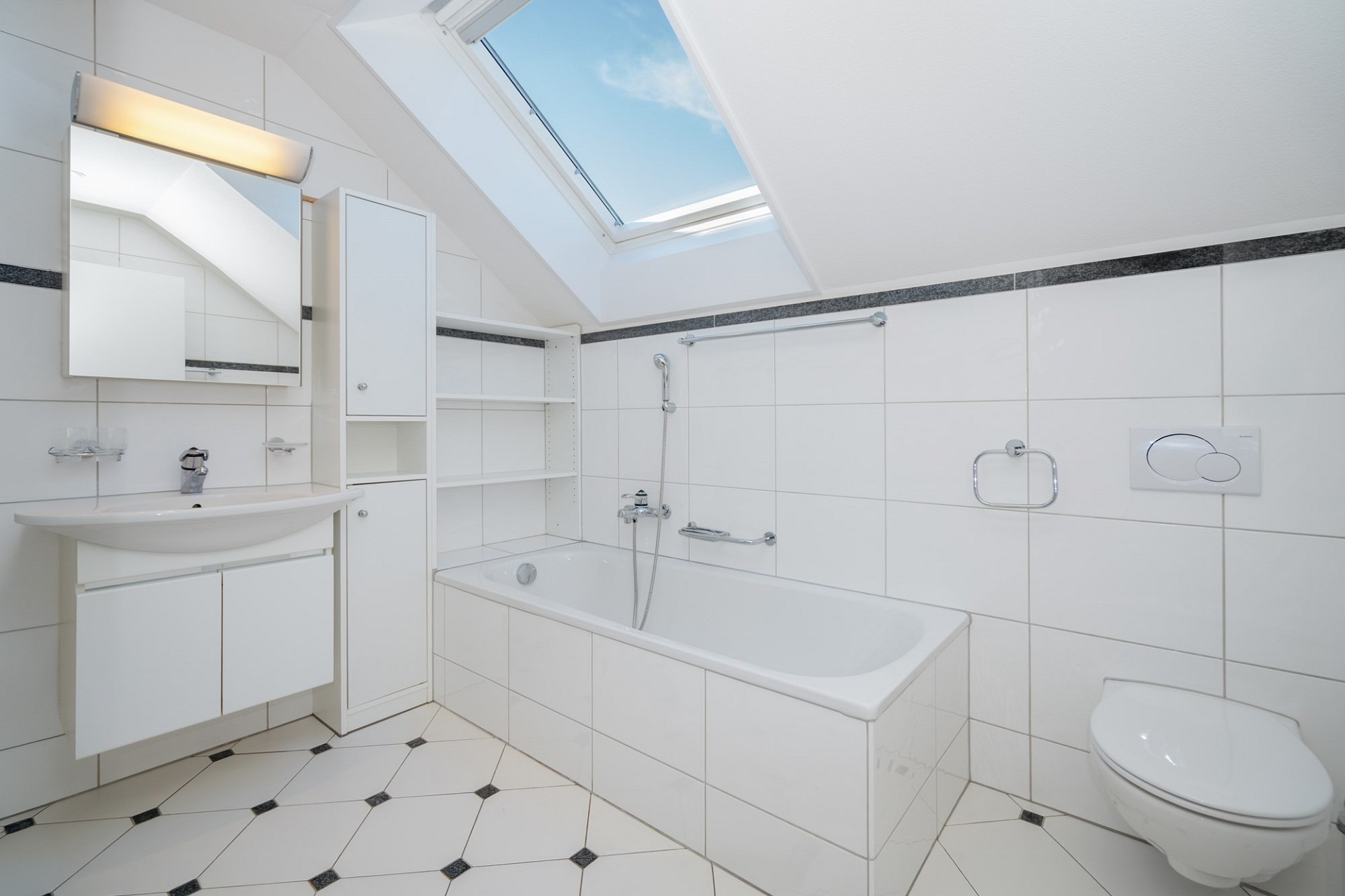 Helles Dachgeschossbad mit Badewanne und Dachfenster