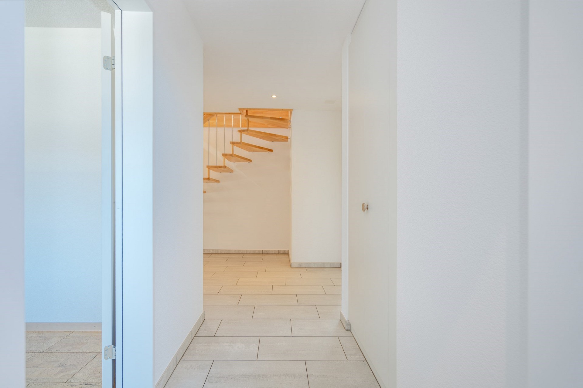Heller Flur mit freitragender Holztreppe