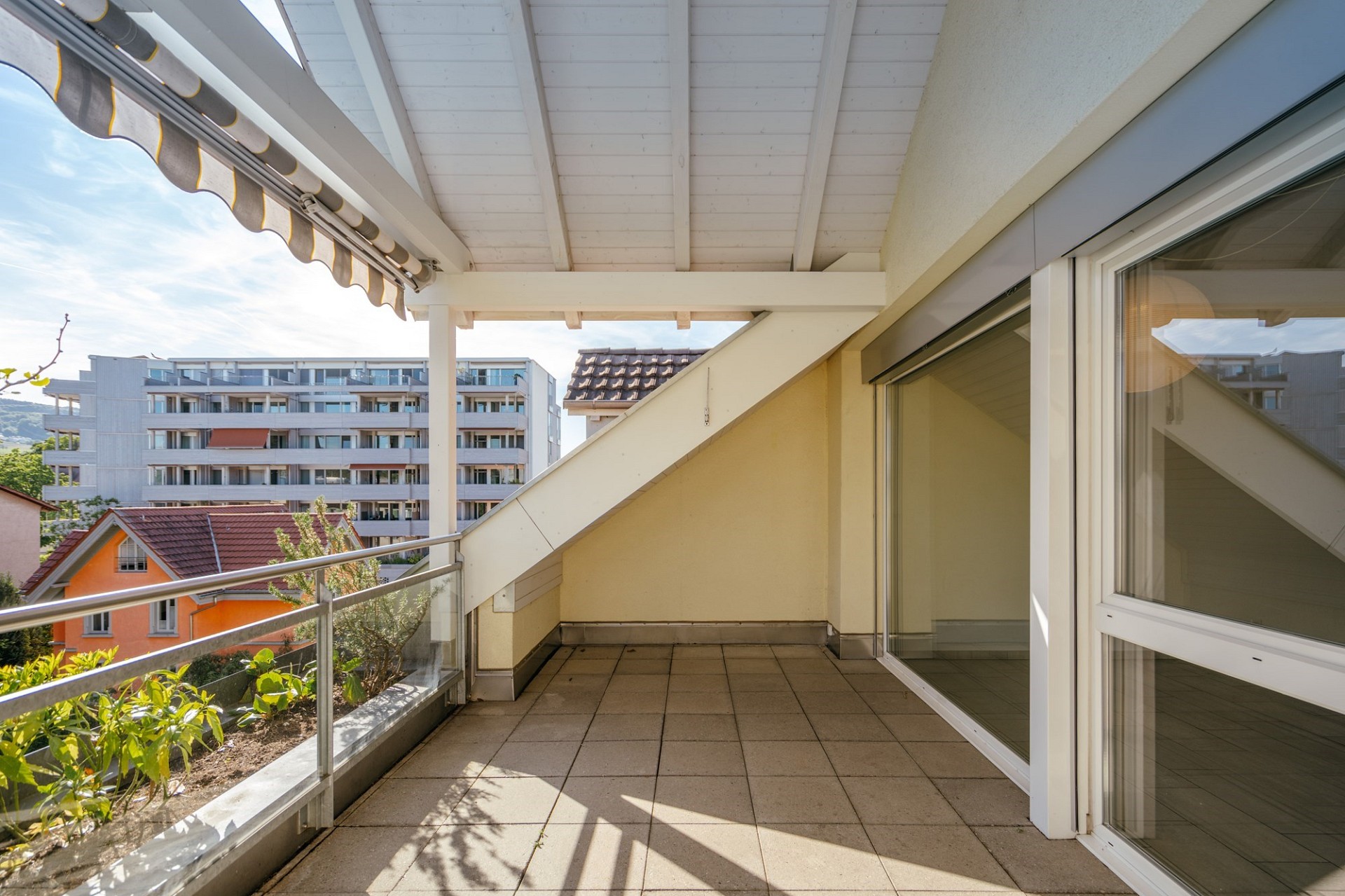 Überdachter Balkon mit Blick ins Wohnumfeld