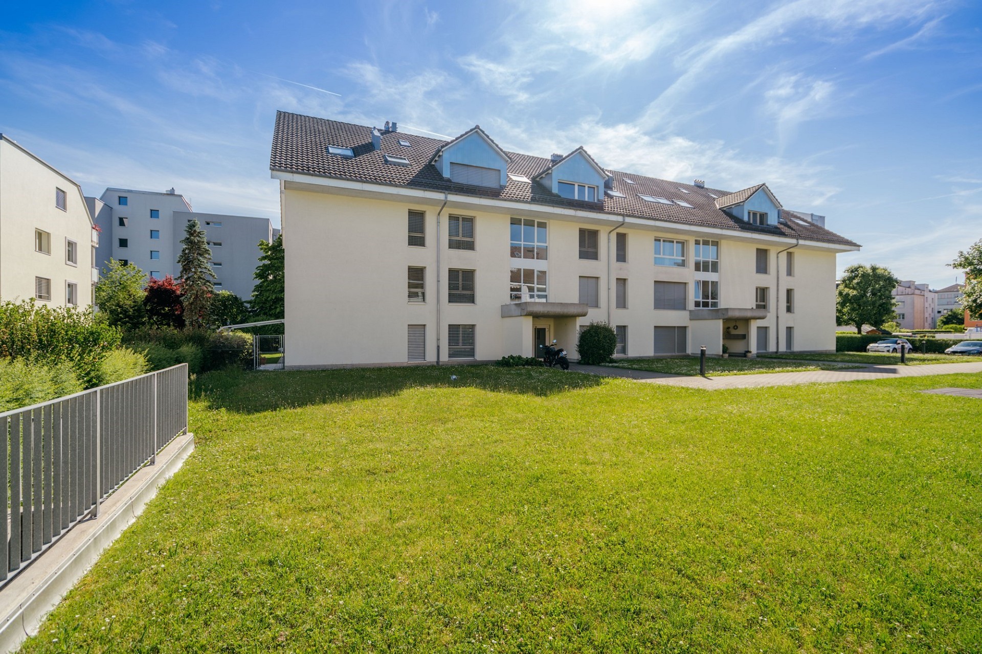 Mehrfamilienhaus mit grüner Außenanlage