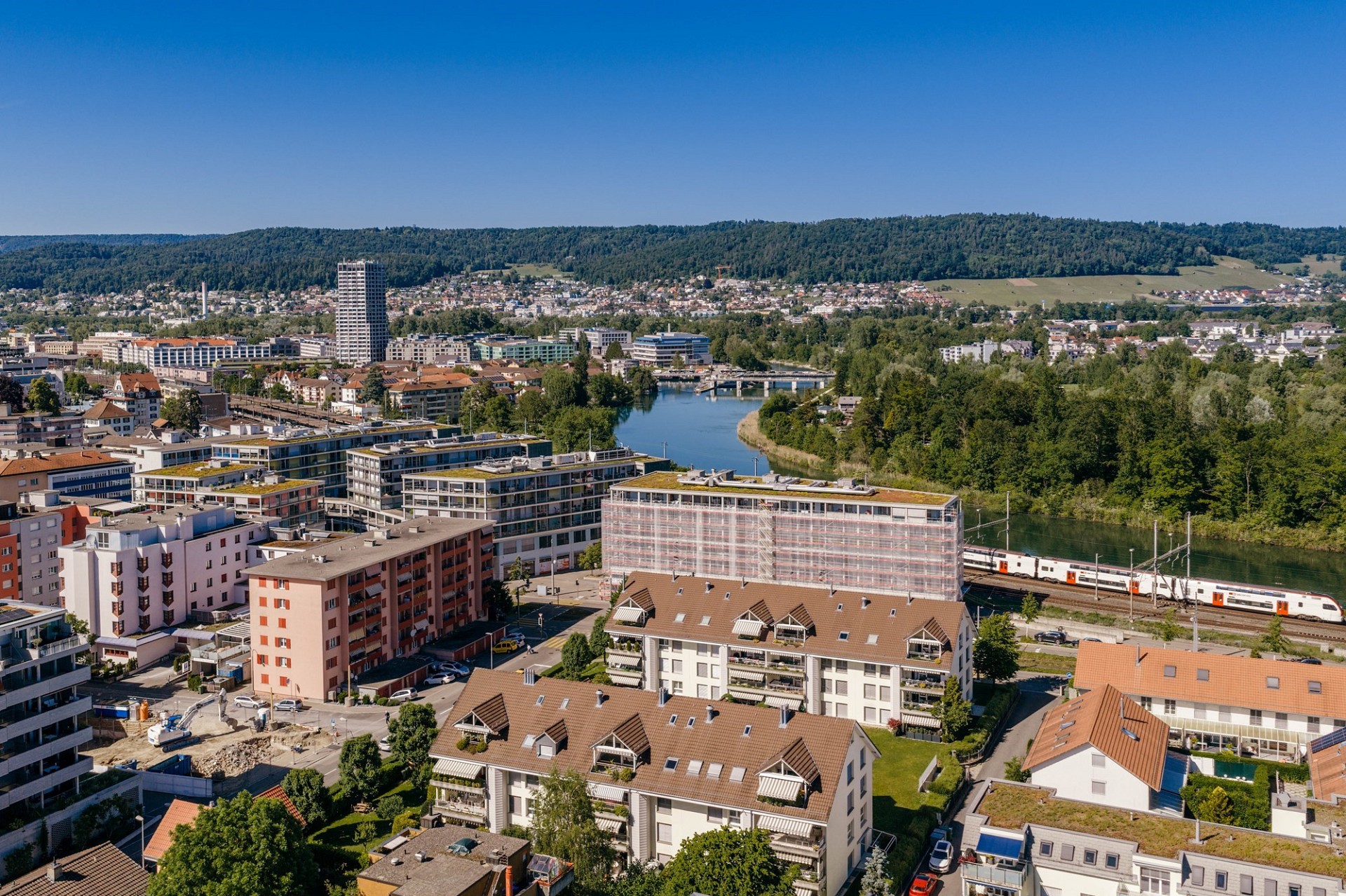 Städtische Luftaufnahme mit Fluss, Wohnhäusern und Bahnhof