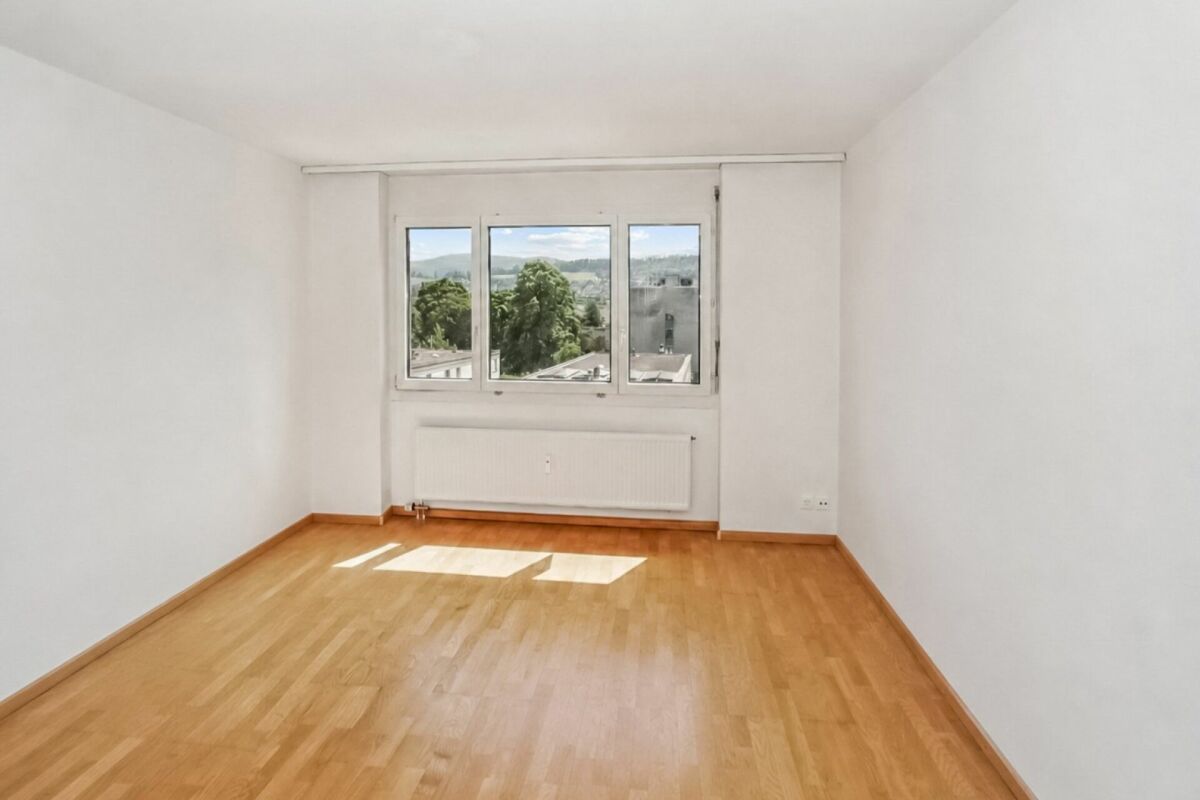 Leerer, heller Raum mit Holzfußboden und Fensterblick