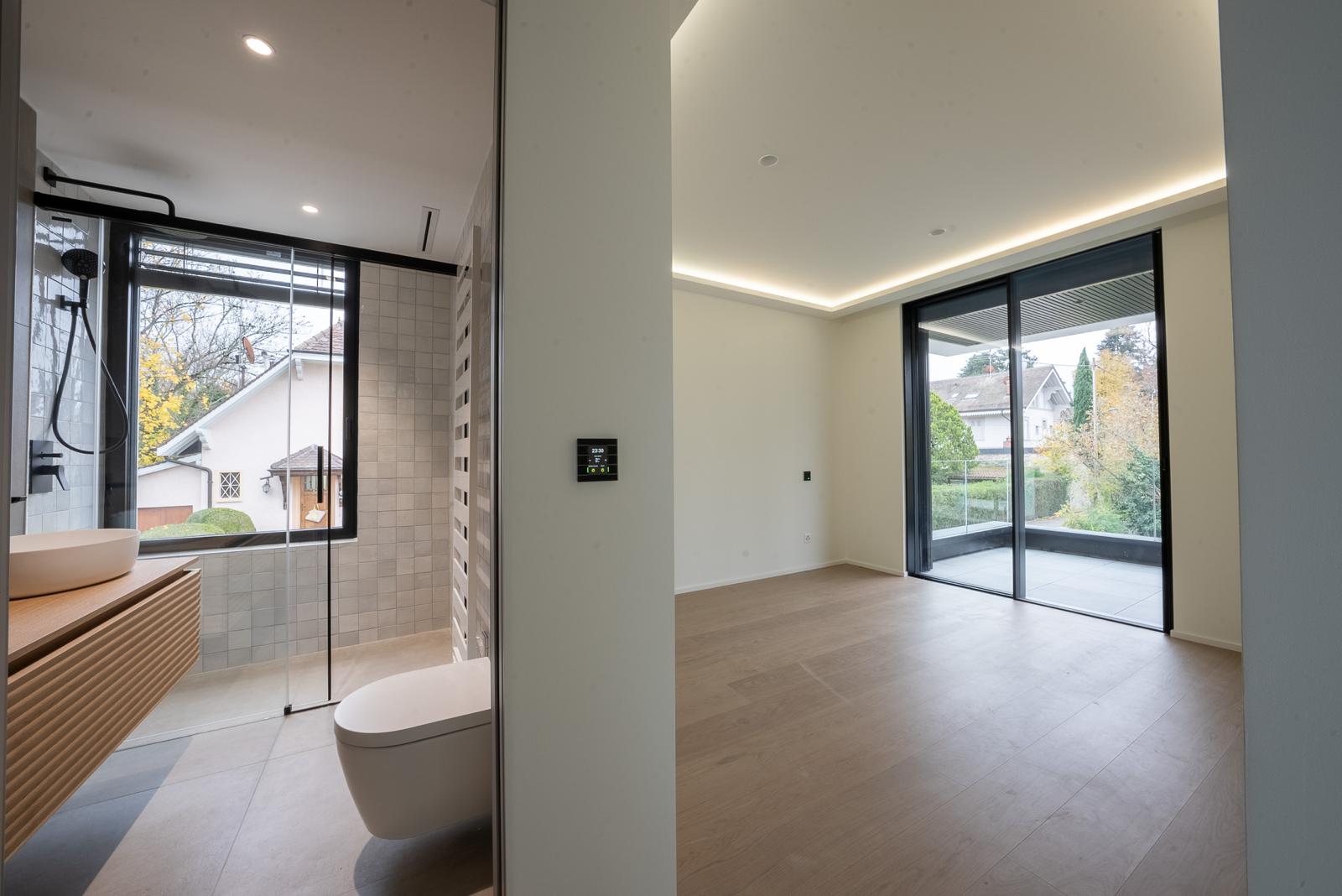 Modernes Bad und angrenzender Wohnraum mit Terrasse