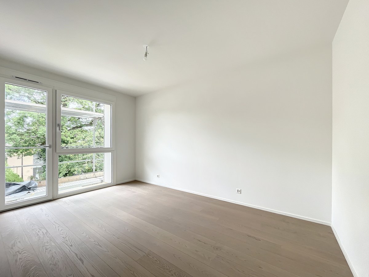 Heller, leerer Wohnraum mit großem Fenster