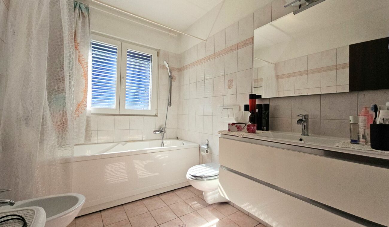 Helles Badezimmer mit Badewanne und Waschtisch