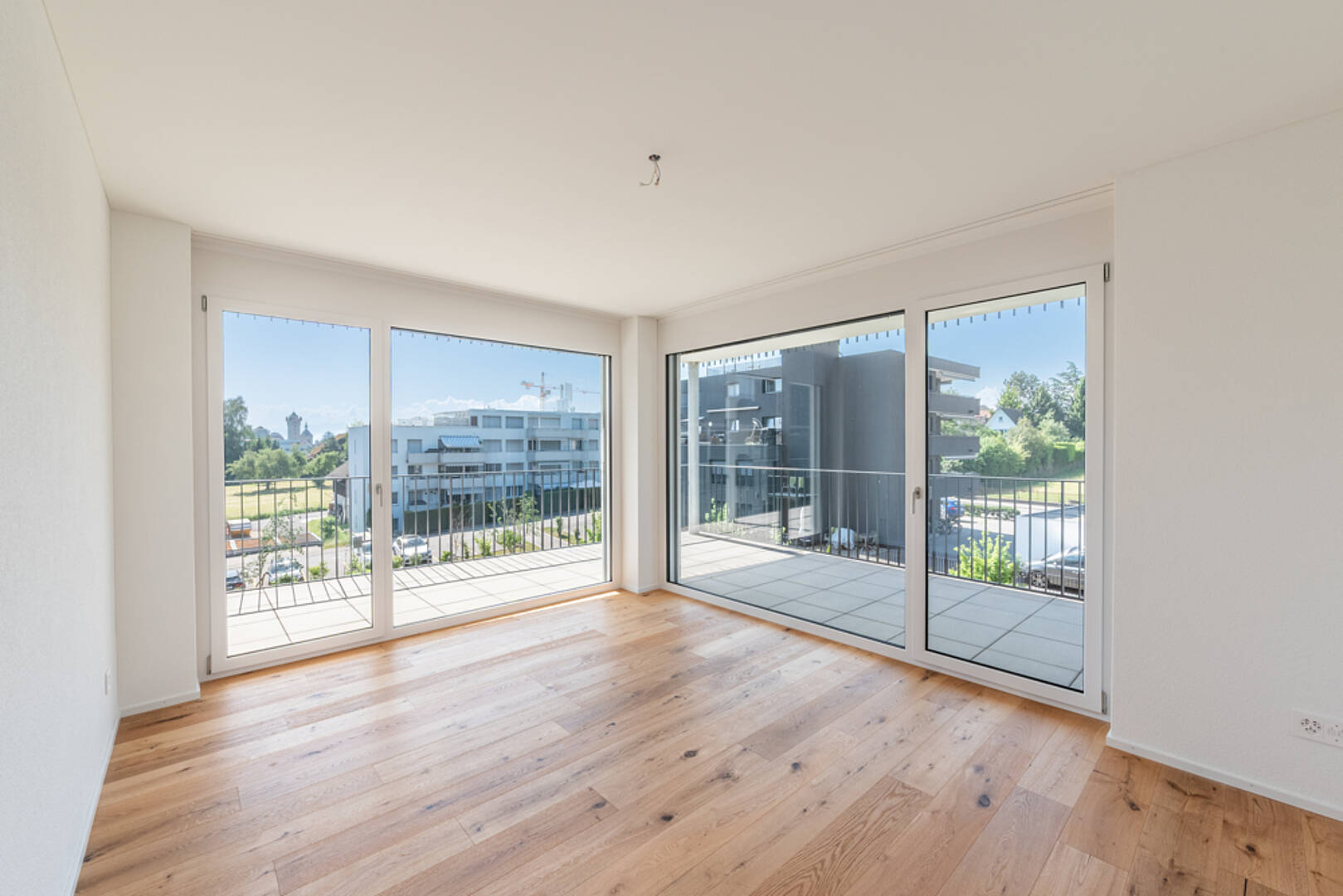 Heller Wohnraum mit bodentiefen Fenstern und Balkon