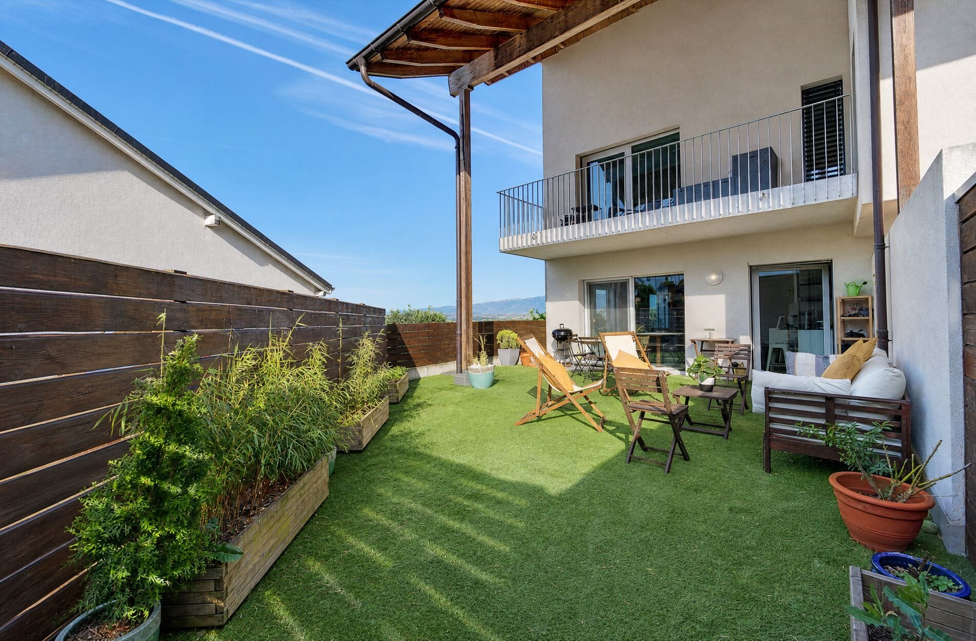 Terrasse mit Sitzgruppe und Hochbeeten