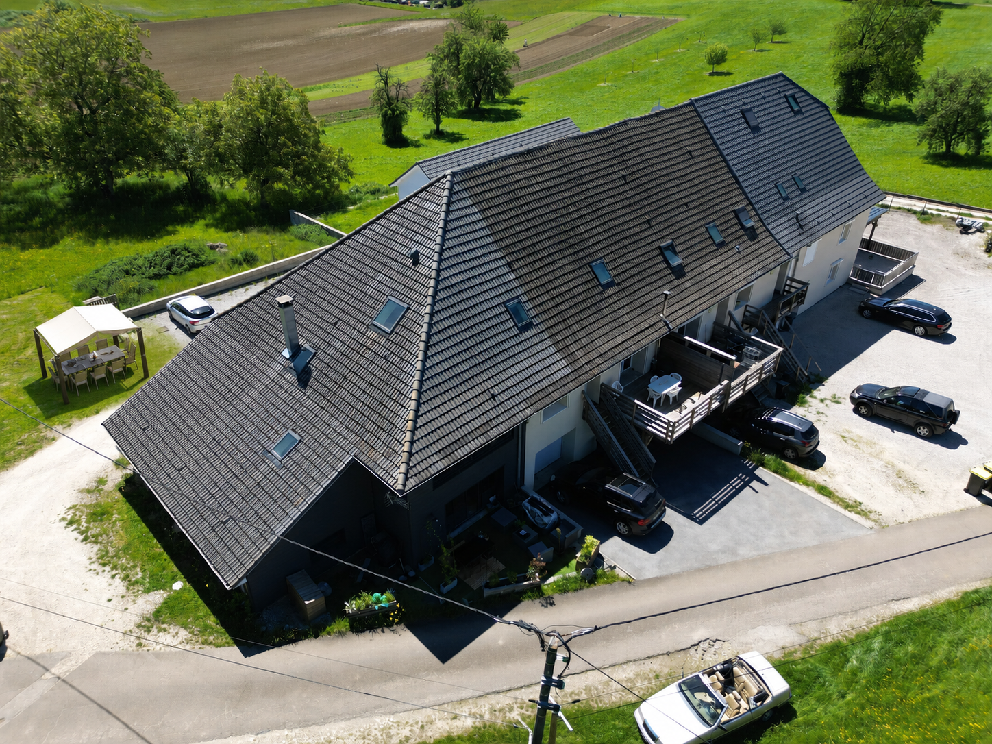 Luftaufnahme eines großen Landhauses mit Parkplätzen und Terrasse