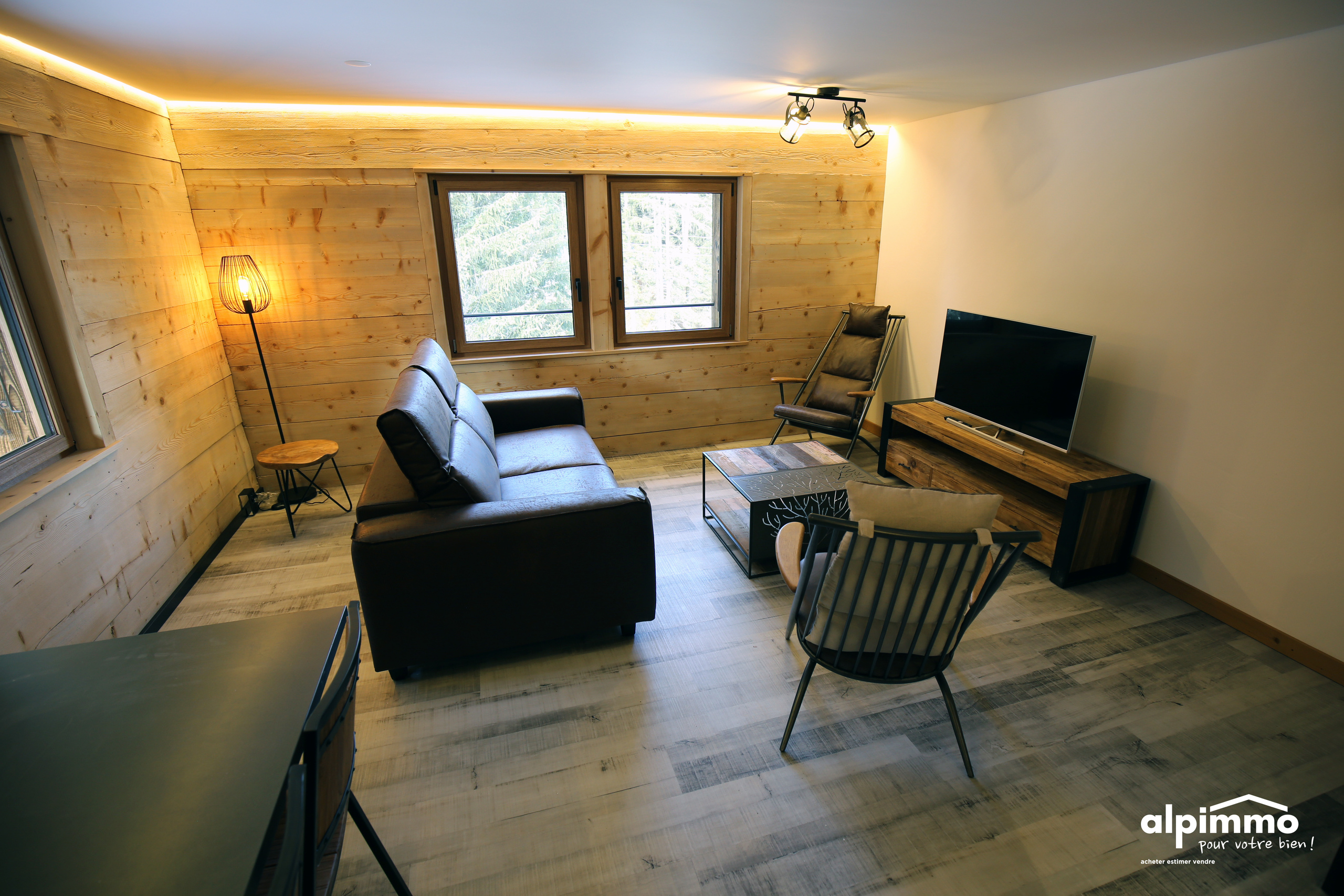 Gemütliches Wohnzimmer mit Holzverkleidung und Lounge-Möbeln