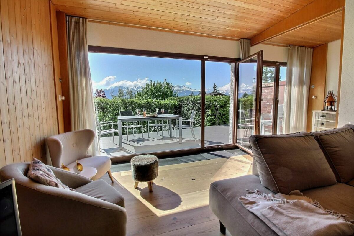 Wohnzimmer mit großer Glasfront zur Terrasse