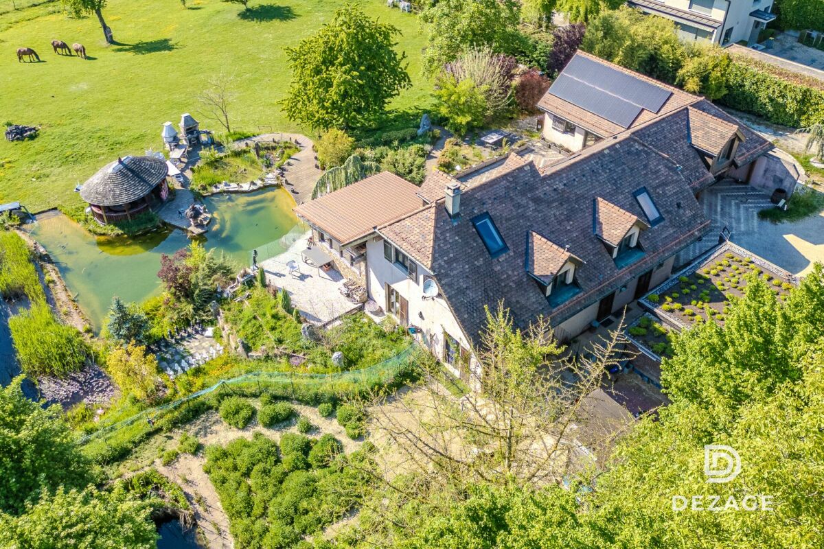 Luftaufnahme eines großen Hauses mit Garten und Teichanlage