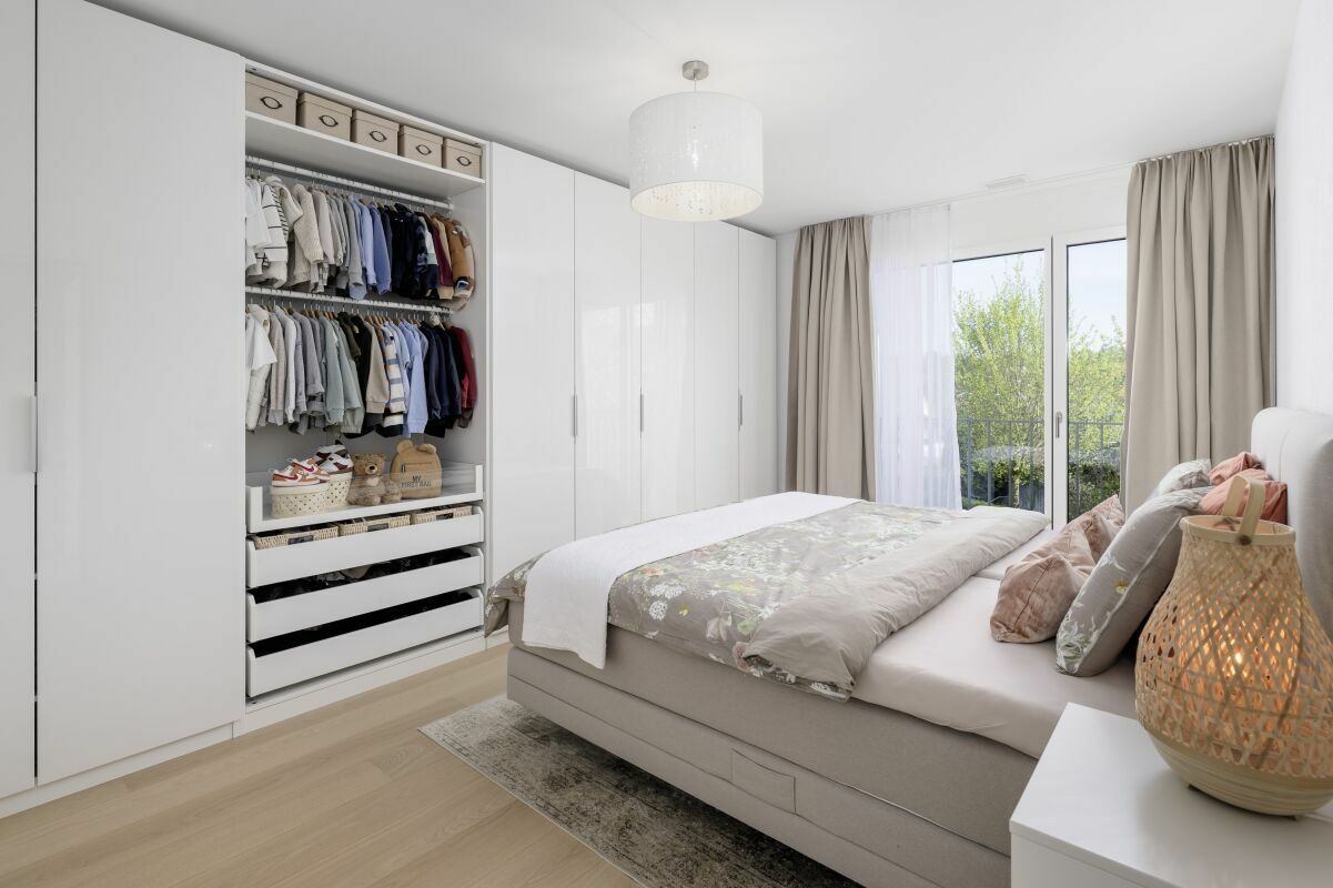 Helles Schlafzimmer mit Einbauschrank und Balkonblick