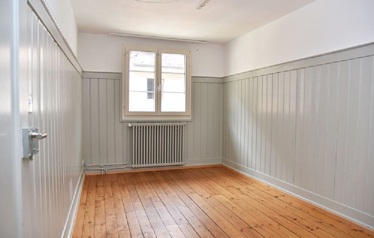 Leerer, heller Raum mit Holzfußboden und Kastenheizkörper