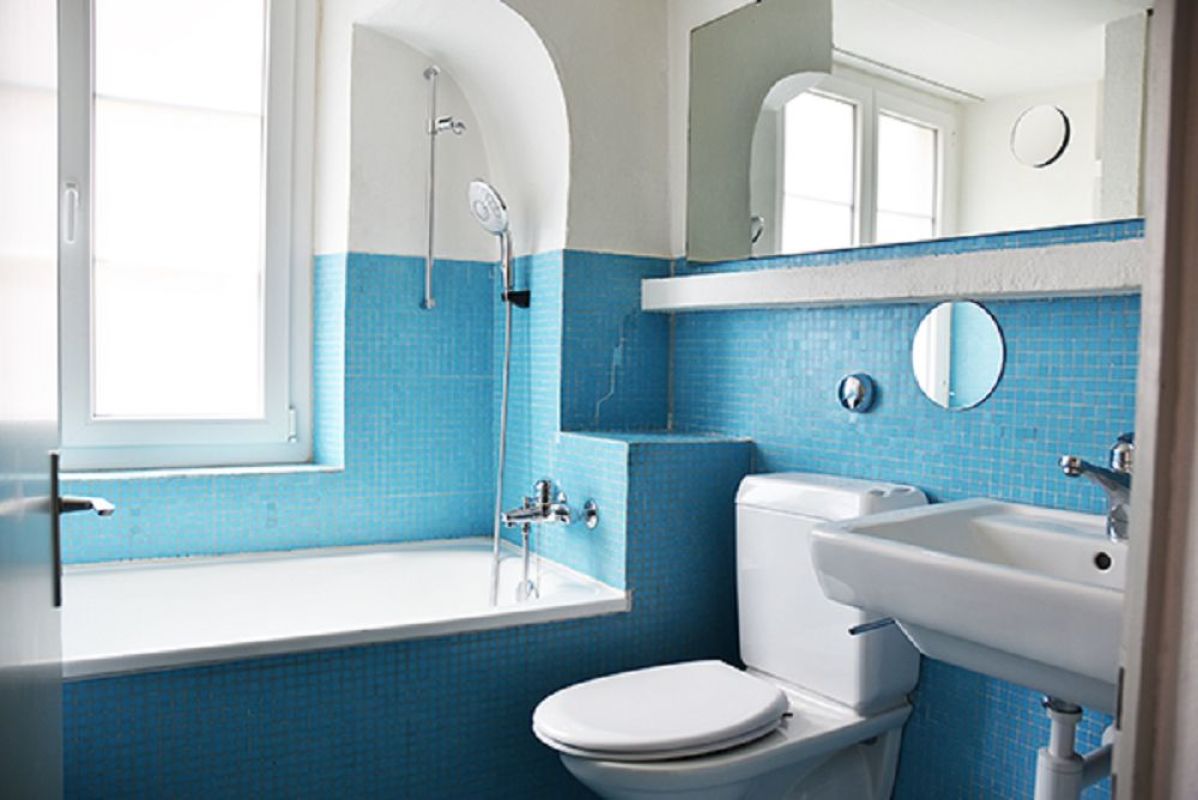 Badezimmer mit blauem Mosaik und Badewanne
