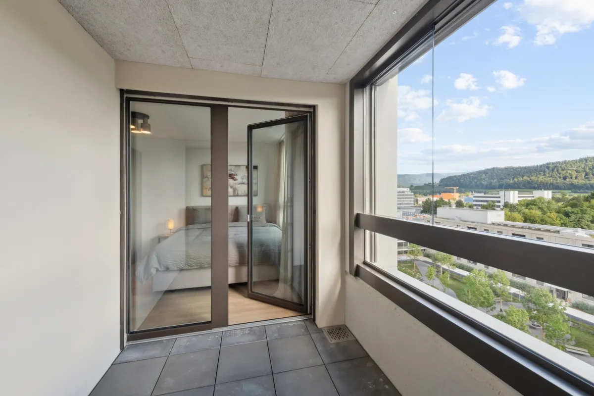 Balkon mit Blick ins Grüne und Schlafzimmerdurchgang