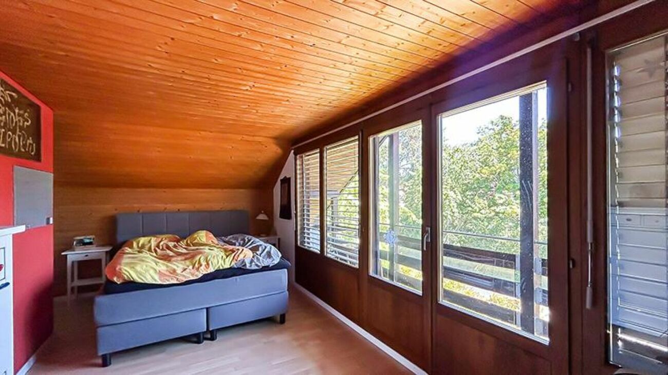Schlafzimmer mit Holzdecke und großem Fensterband