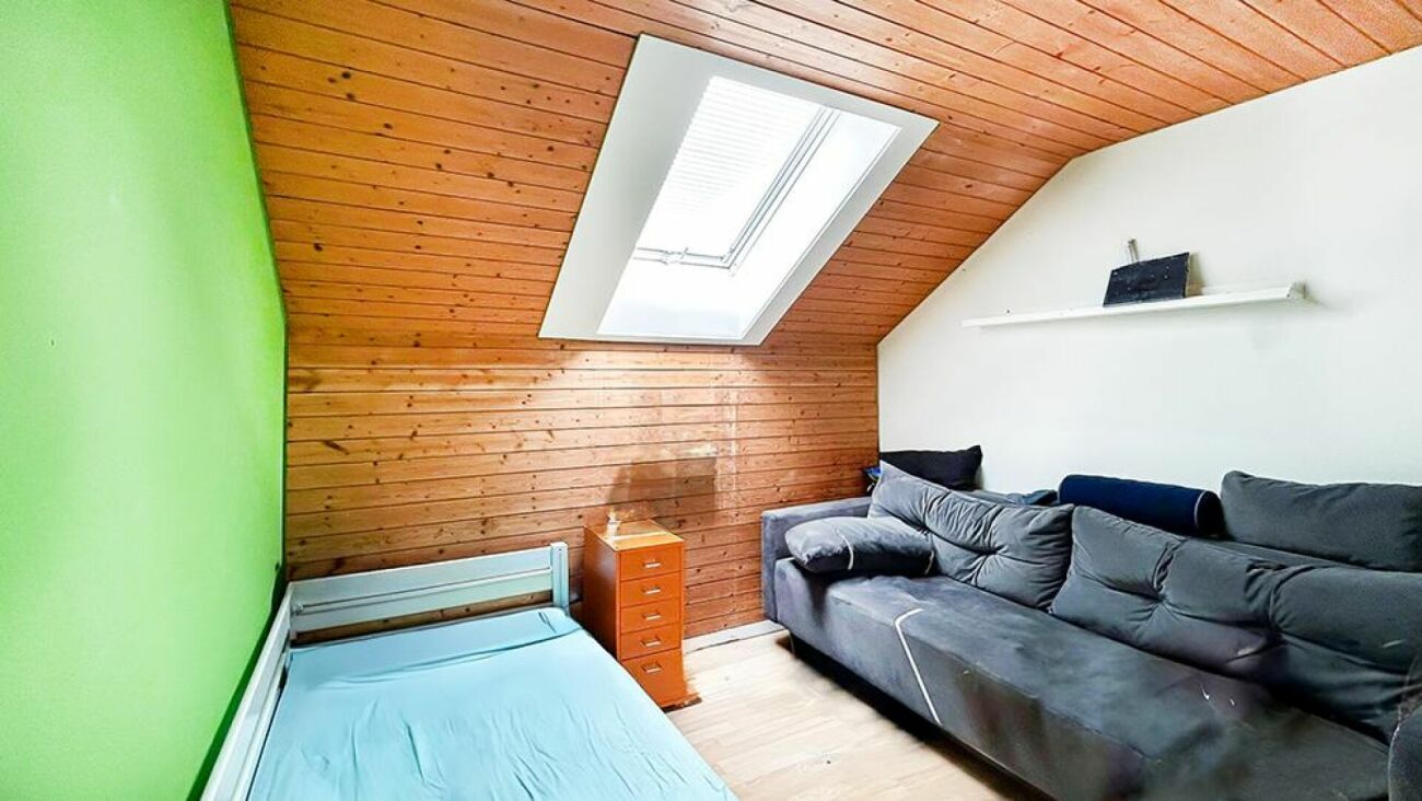 Dachzimmer mit Bett und Sofa