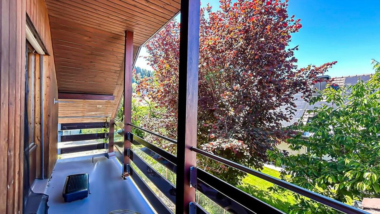Balkon mit Holzverkleidung und Blick ins Grüne