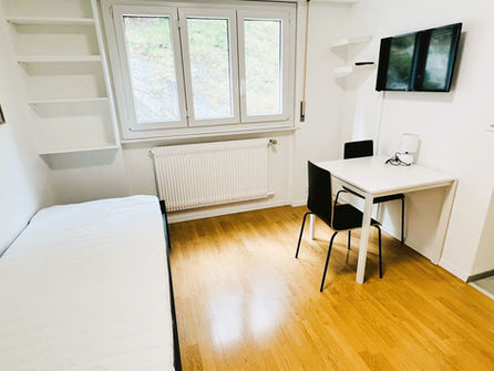 Helles kleines Schlafzimmer mit Schreibtisch