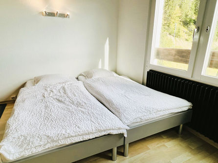 Helles Schlafzimmer mit Doppelbett und Fenster