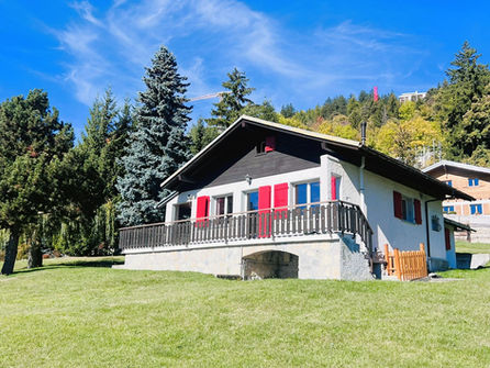 Berghaus mit roter Fensterlädenfassade