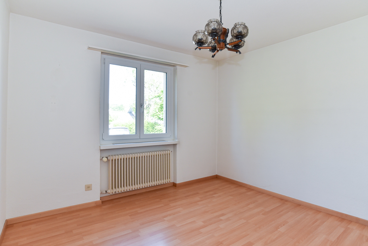 Leerer, heller Raum mit Fenster und Heizkörper