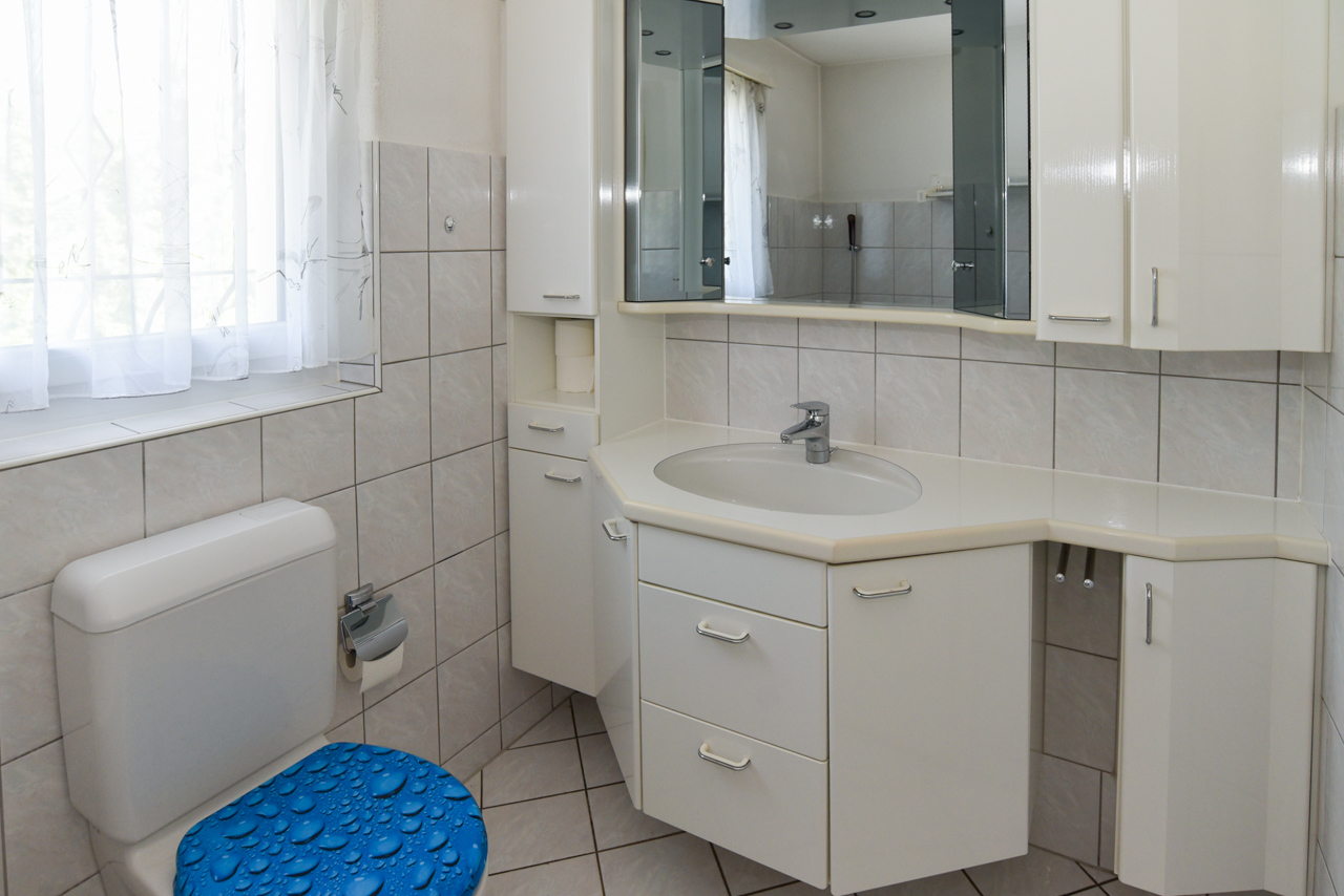 Helles Badezimmer mit weißer Einbaumöblierung