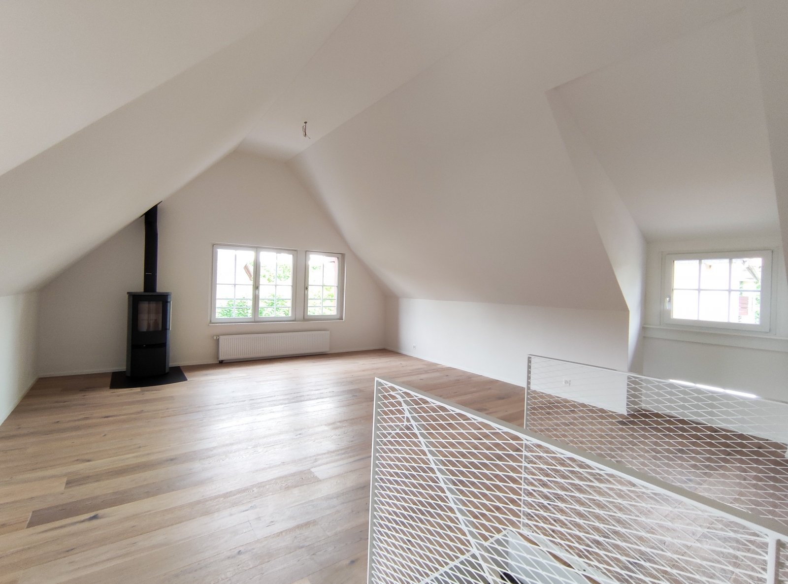 Dachgeschossraum mit Kamin und Dachfenstern