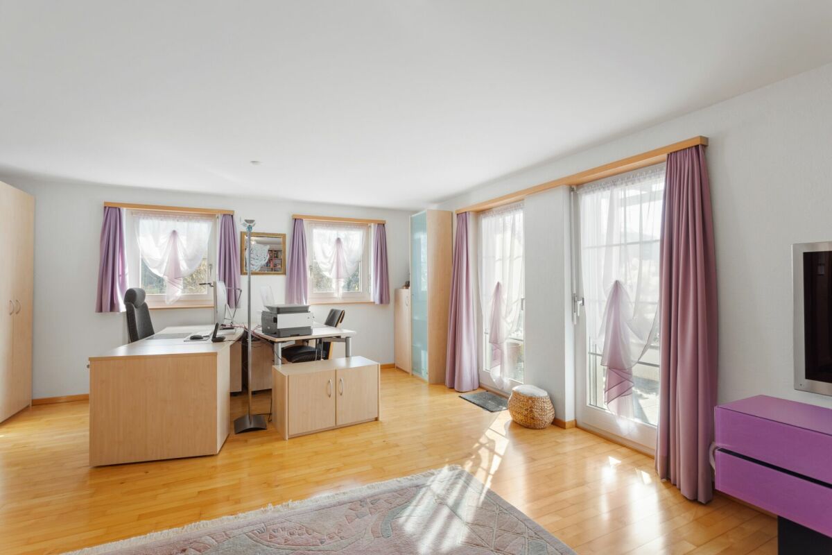 Helles Arbeitszimmer mit großen Fenstern und Schreibtisch