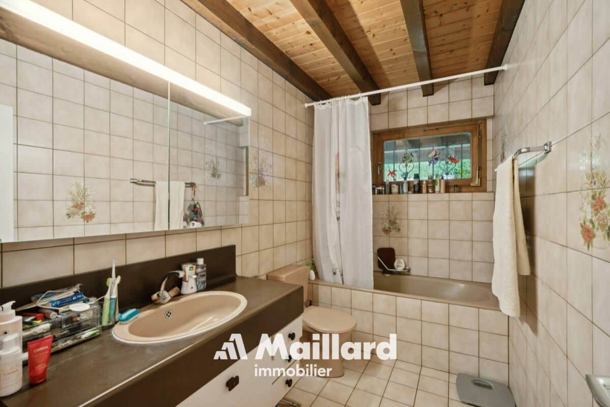 Badezimmer mit Badewanne und Holzdecke