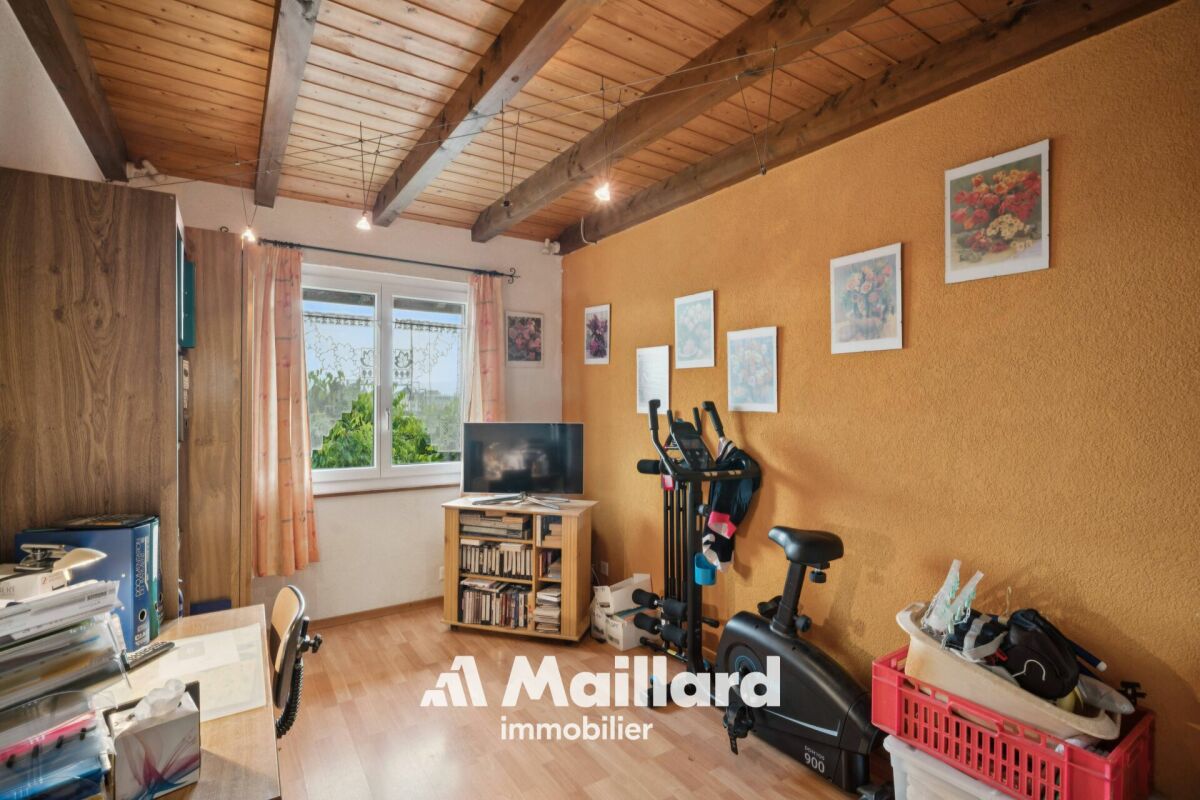 Heller Arbeits- bzw. Fitnessraum mit sichtbarer Holzbalkendecke