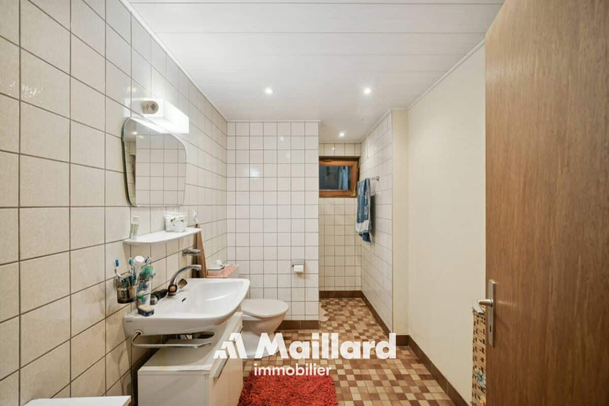 Schmales Badezimmer mit Retro-Fliesen und Holz­tür