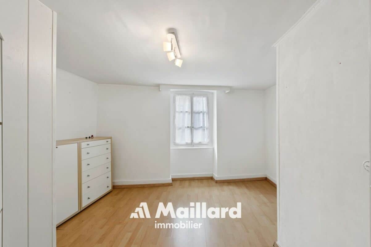 Helles, leeres Zimmer mit Holzboden und Fenster