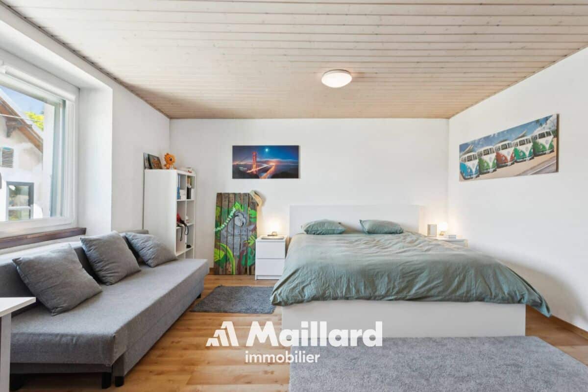 Helles Schlafzimmer mit Sofa und Blick nach draußen