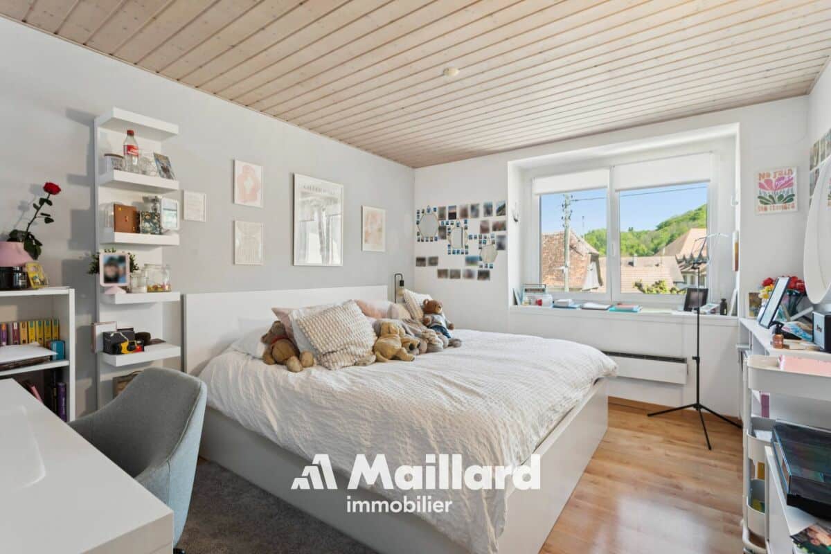 Helles Schlafzimmer mit Dachschräge und Blick ins Grüne