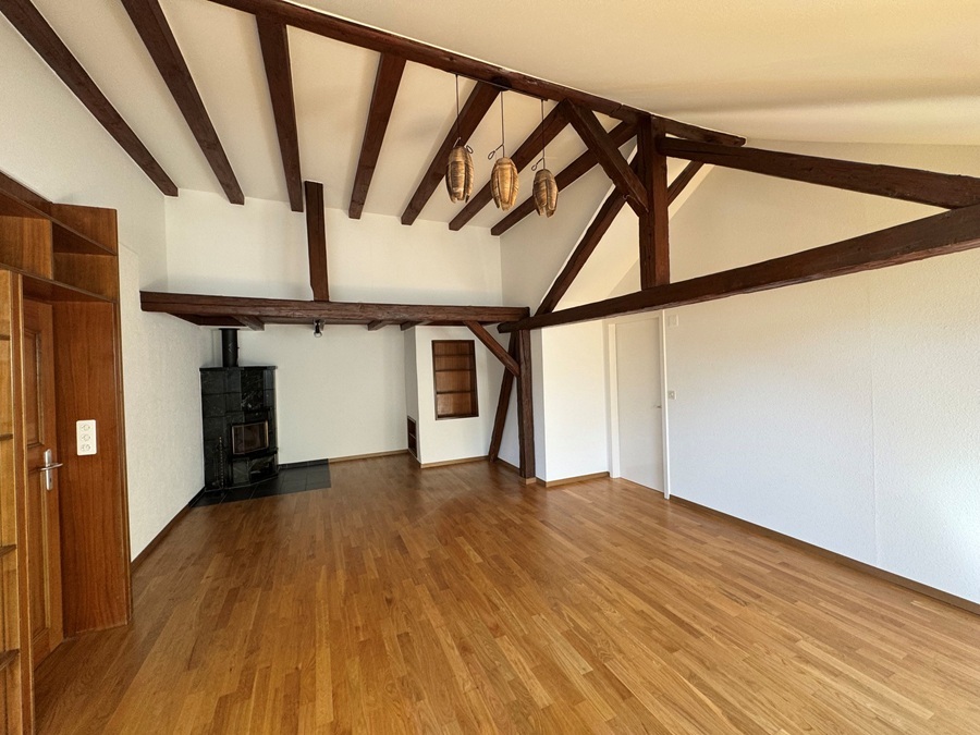Wohnraum mit sichtbaren Holzbalken und Kamin