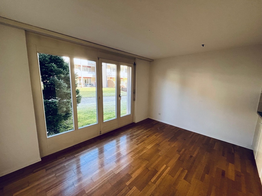 Leeres Zimmer mit großen Fenstertüren zum Außenbereich