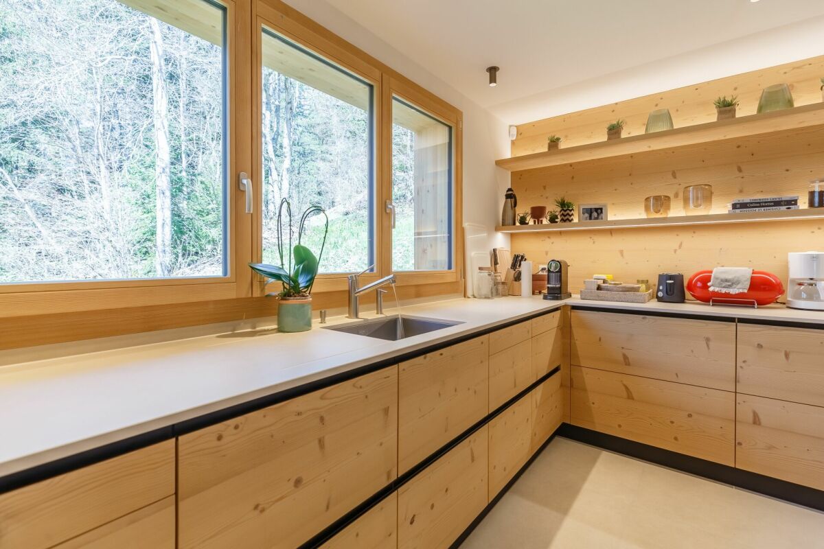 Helle Küche mit Holzfronten und großem Fenster