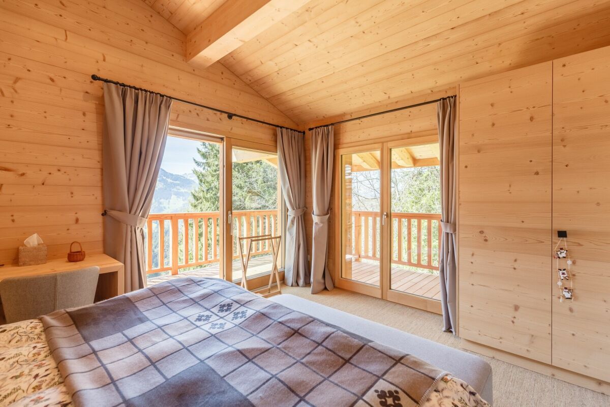 Gemütliches Holzschlafzimmer mit Balkonblick