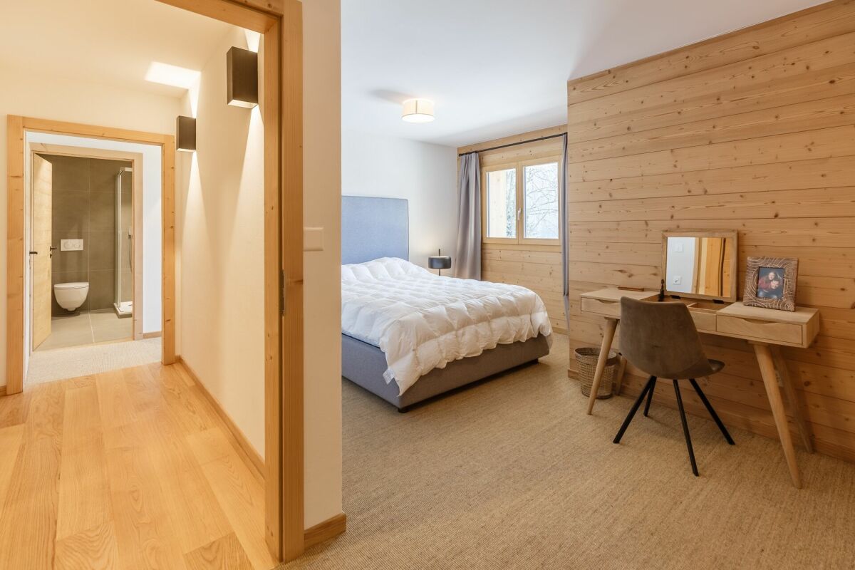 Schlafzimmer mit angrenzendem Bad und Holzvertäfelung