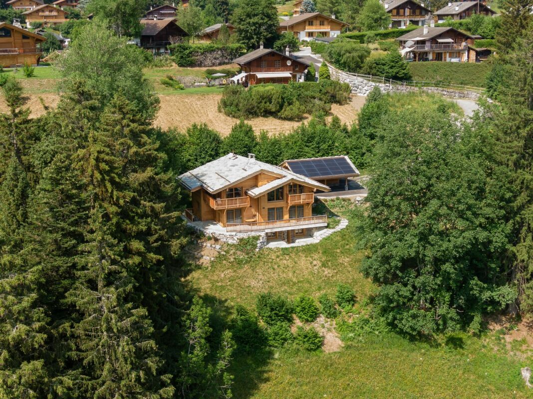Luftaufnahme eines Chalets in grüner Hügellage