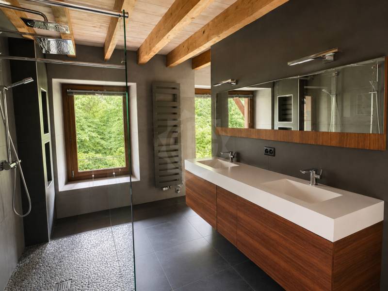 Modernes Badezimmer mit Doppelwaschtisch und Fensterblick ins Grüne