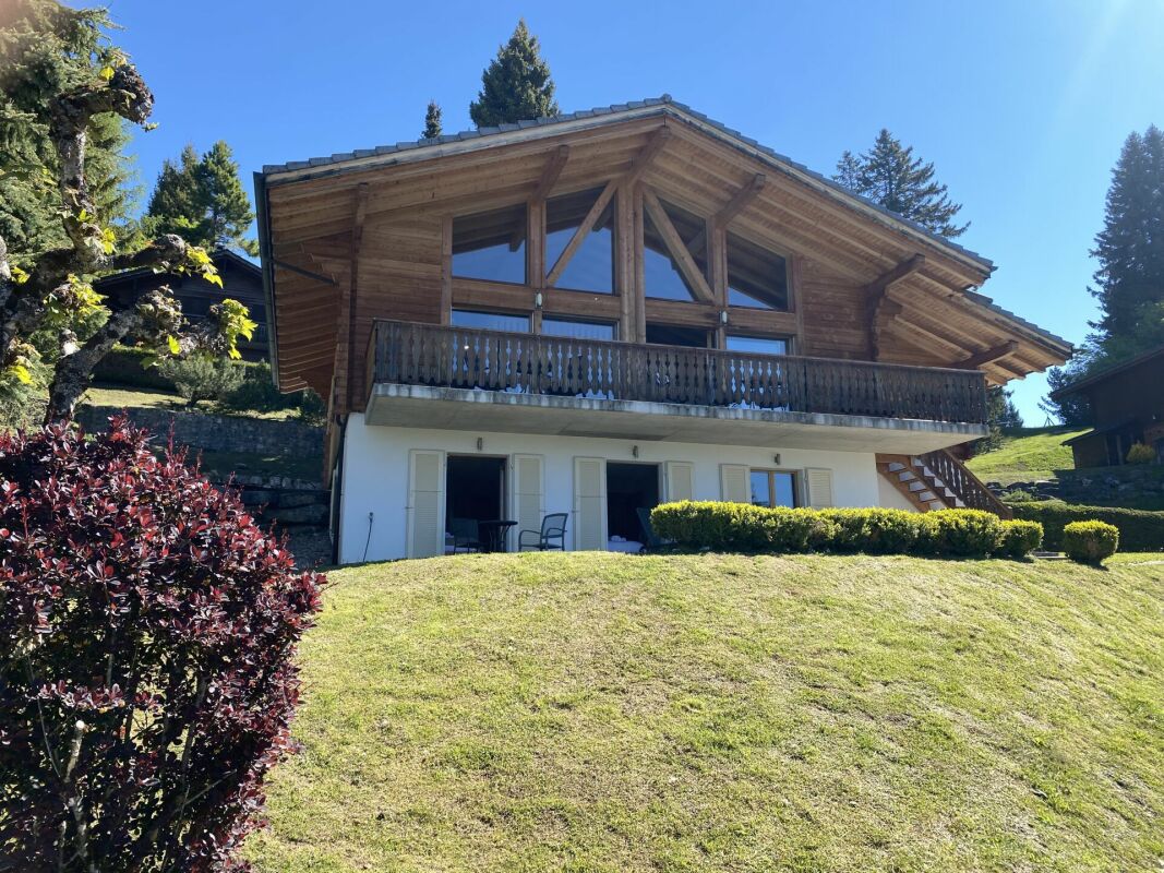 Holzchalet mit Balkon und Gartenhang