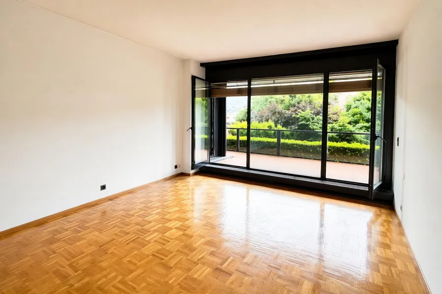 Leerer Wohnraum mit Balkonzugang