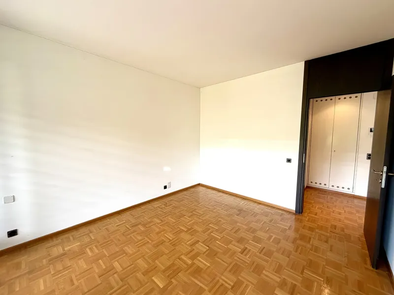 Leerer Raum mit Parkett und angrenzendem Einbauschrank