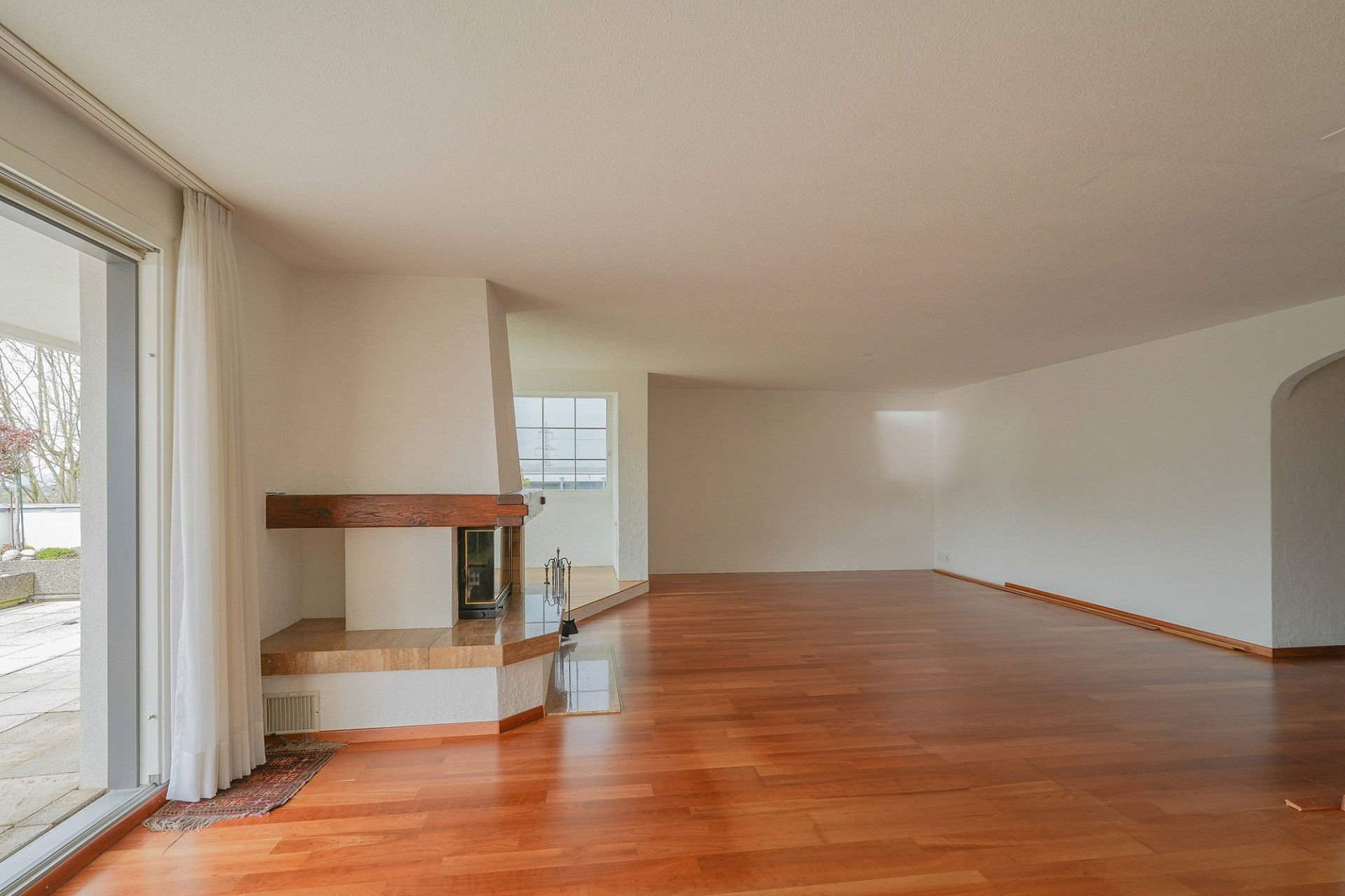 Großzügiges Wohnzimmer mit Kamin und Parkett