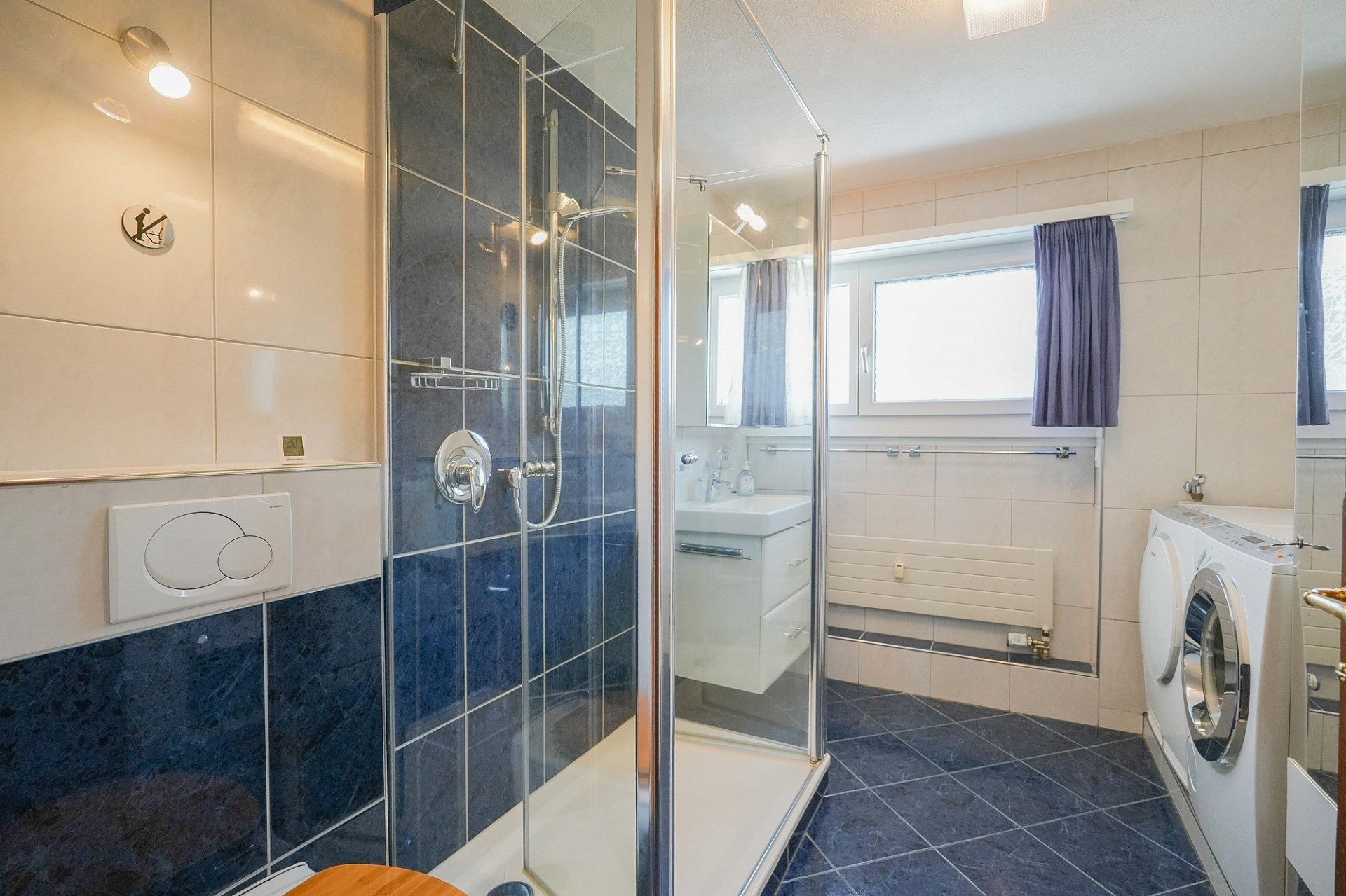 Badezimmer mit Dusche und Waschmaschine